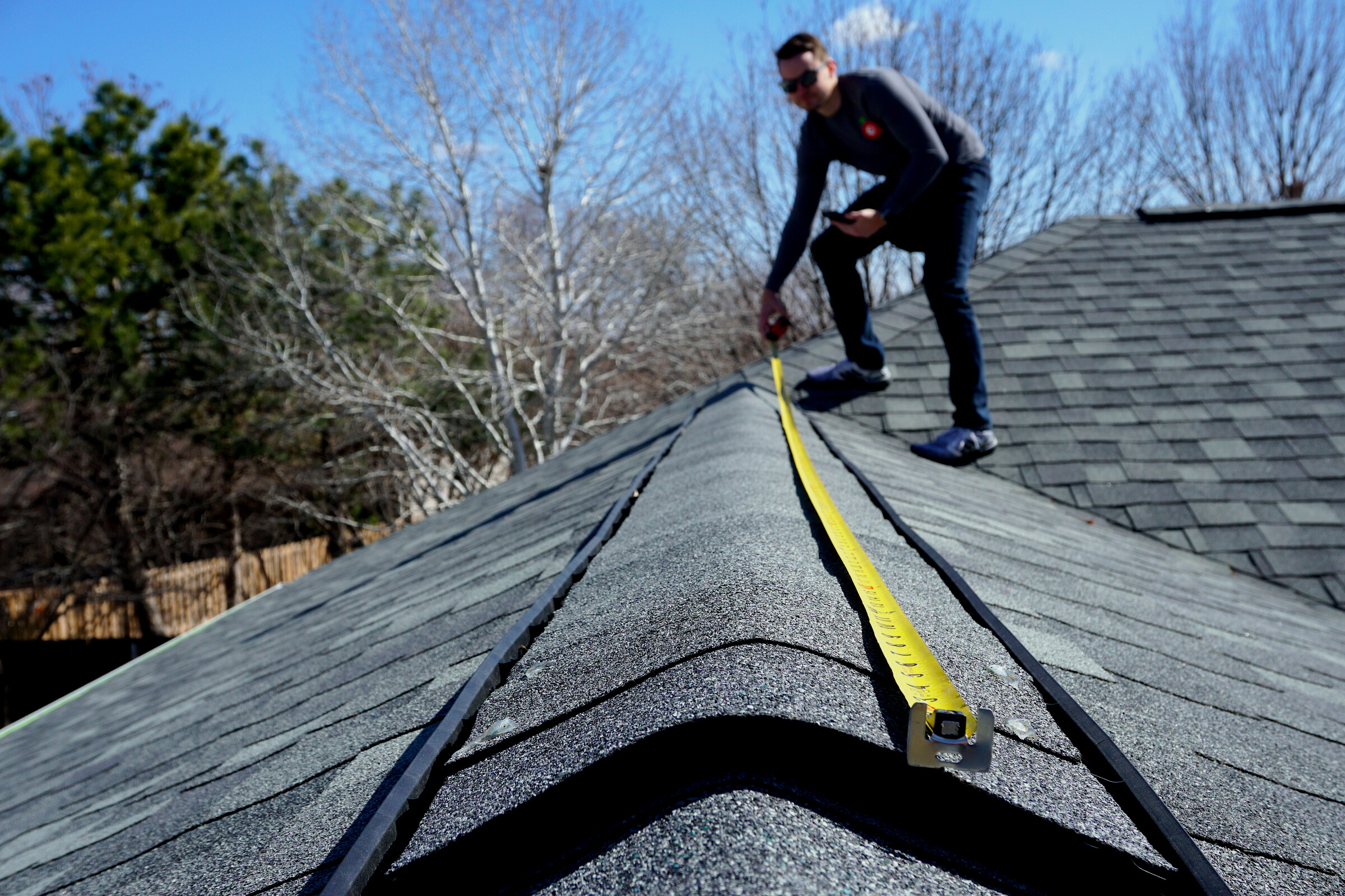 A Man Measuring the Roof